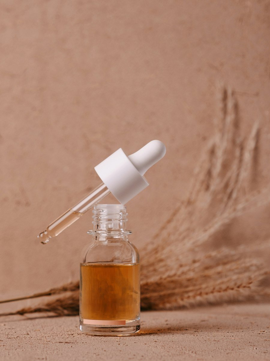 Amber serum dropper on a warm stone backdrop
